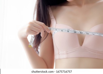 Closeup beautiful young asian woman sexy body slim measuring breast for control weight loss in the room, beauty asia girl figure thin measure size of bust for diet, health and wellness concept.