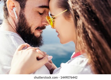 Close-up of a beautiful young mixed race couple enjoying togetherness while traveling in a warm country during their summer holidays. Concept of warm feelings and emotions of lovers