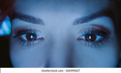 Close-up Of Beautiful Young Woman Eyes Looking At Monitor, Working With Computer, Laptop. Monitor Blue Light Is Reflected In Her Eyes. Evening Woman Freelancer Working, Shopping Online, Watch Video.