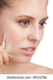 Close-up Of Beautiful Young Woman Removing Old Damaged Skin From Her Face