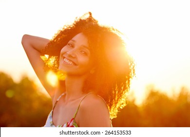 Nahaufnahme einer schönen jungen Frau mit einem Sonnenuntergang hinter ihr