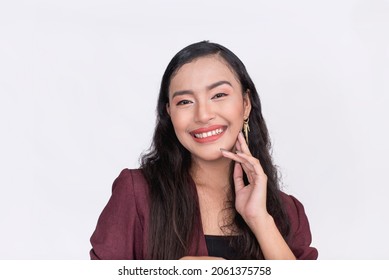 Closeup Of A Beauty Filipina With A Wide Perfect Smile. Fingers On The Side Of The Cheek. Isolated On White Background.