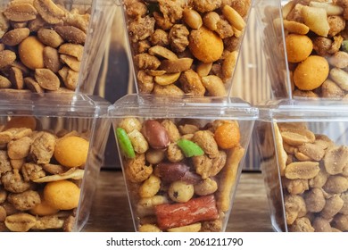 Close-up Of A Beer Snack. Hazelnuts, Cashews And Peanuts With Different Flavors In Transparent Packaging. Snacks Go With Alcohol. Takeaway Food. Concept