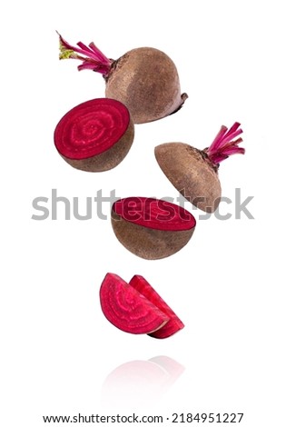 Closeup beetroot (beet root) and half sliced flying in the air isolated on white background.