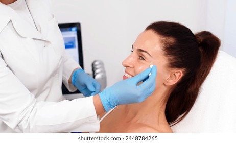 Close-up. Before the procedure for facial contouring or plastic surgery, the cosmetologist makes markings on the patient’s face. Time to prepare for a cosmetic procedure. - Powered by Shutterstock