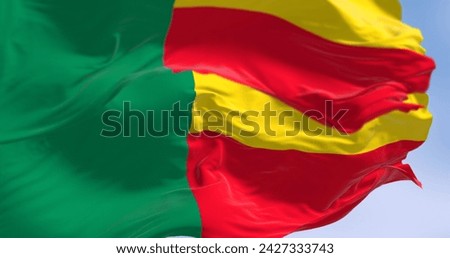 Close-up of Benin national flags waving. Two horizontal yellow and red bands on the fly side and a green vertical band at the hoist. 3d illustration render. Fluttering fabric. Selective focus