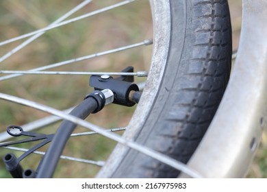 Close-up of bicycle tire inflating valve.Pump valve connected to the wheel.