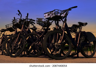 Close-up Bicycles Stand In The Parking Lot Against The Backdrop Of A Beautiful Sky. No People . Bike With A Basket For Things