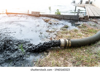 Close-up Big Pipe Of Power Pump Machine Pouring Mud Sludge Waste Water With Sand And Silt On Ground. Sand-wash And Coast-depeening. Septic Sewage Maintenance Service. Industrial Environment Pollution