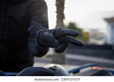 Close-up of a biker's hands showing the hand gestore of salute, the V gesture - Powered by Shutterstock