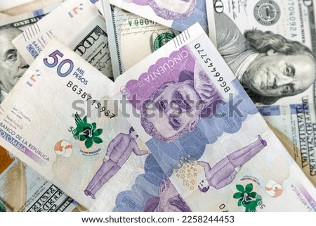 Close-up of bills of 50 thousand Colombian pesos and bills of 100 dollars