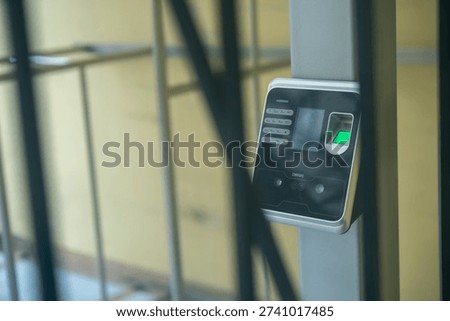 A close-up of a biometric security access control device, featuring a fingerprint scanner and keypad. Ideal for concepts of safety and technology in modern security systems.