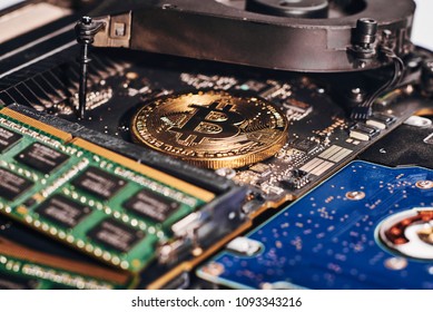 Close-up of bitcoin mining process - gold coin on computer circuit board with bitcoin processor and microchips. Electronic currency, internet finance crypto currency concept.