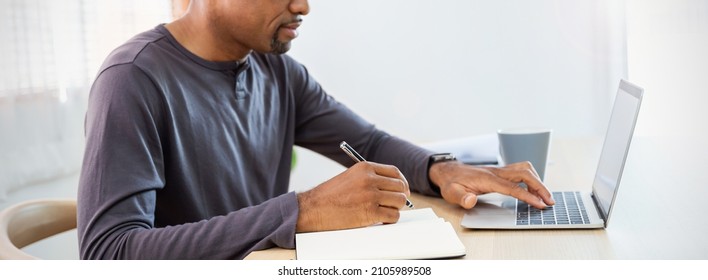 Closeup Black Businessman Hand Holding Pen Writing On Notebook, Work On Laptop Computer In Modern Office Student Lecturing While Studying Online Internet Course Write On Journal Diary Panoramic Banner