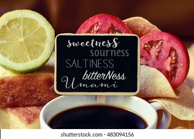 closeup of a black chalkboard with the name of different tastes, such as sweetness, sourness, saltiness, bitterness or umami, placed on a pile of some different products representative of this tastes
