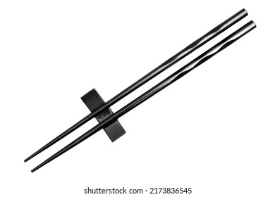 Close-up of black chopsticks placed on a resting base isolated on white background. - Powered by Shutterstock