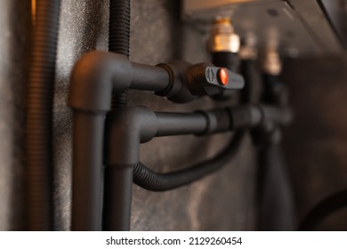 Close-up of black connected polypropylene pipes and tap.