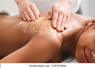 Closeup Of Black Girl Having Skin Peeling Massage At Spa, Therapist Scrubbing Woman Back