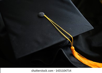 Close-up Black Graduation Hat and Yellow Tassel placed on the floor