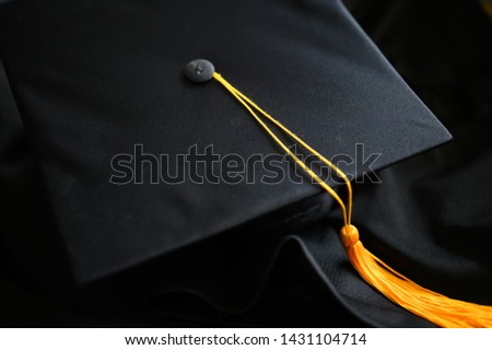 
Close-up Black Graduation Hat and Yellow Tassel placed on the floor