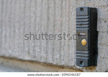 Close-up black intercom on  grey wall on house entry