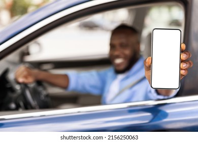 Closeup Of Black Male Driver Holding Smartphone With Blank Screen In Hand, Mock Up, Guy Showing Cell Phone With White Empty Display, Using Mobile App For Navigation, Free Copy Space, Selective Focus