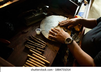 Close-up Of Black Man Hands Roll Cigars From Tobacco Leaf At The Cigar Factory In Latin America. 