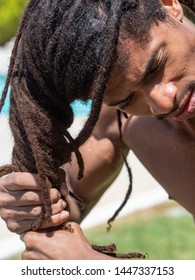 Close-up of a black man who slips his dreadlocks when he comes out of the pool.