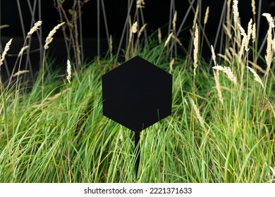 Closeup Black Metal Sign At Green Grass Background, Nameplate With A Space For Your Text. Horizontal Banner