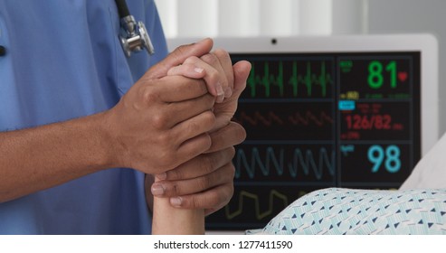 Closeup Of Black Nurse Hands Holding White Womans Hand In Bed