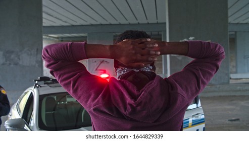 Close-up Black Offender In Mask Caught Red-handed By The Police. Two Old Friends Afro-american Men Cop And Thief Meeting At Arrest. Amazing Fun Scene. Police On Duty.