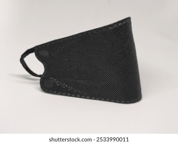 A close-up of a black protective face mask on a white background, ideal for promoting health, safety, or fashion-related content. - Powered by Shutterstock