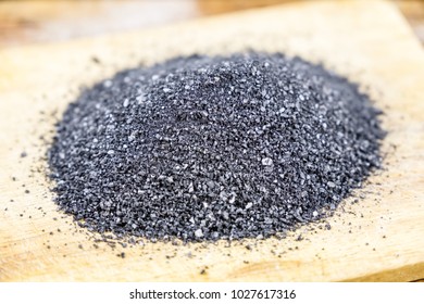 Close-up black salt on wooden board