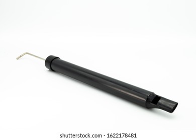 Closeup Of A Black Slide Whistle Lying On A White Background