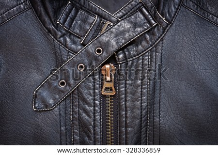 Close-up of black synthetic leather jacket showing a zipper and a collar belt