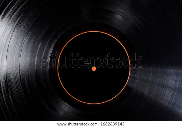 Closeup of black vinyl record and black lable\
of it as a background