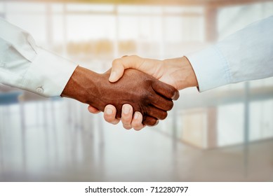 Close-up Of A Black And White Hands Shaking Over A Good Business Agreement.