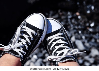 closeup of black and white sneakers with a blurred rocky background - Powered by Shutterstock