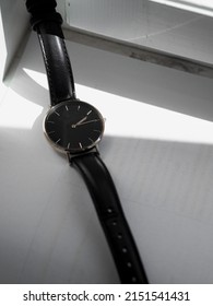 A Closeup Of A Black Wristwatch On A White Surface