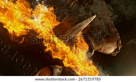 Close-up of blacksmith forging glowing hot iron on anvil with flying sparks