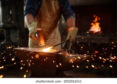 Close-up of blacksmith manually forging the molten metal in the workshop - Powered by Shutterstock