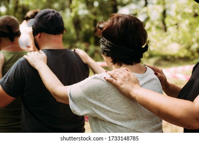  Close-up Of Blindfolded People Hold On To The Shoulders Of The Person In Front