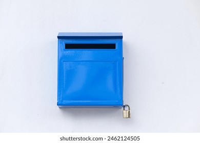 Close-up blue color iron mailbox on square shape that installed on white concrete wall for receive newspaper, letter, document and other from postman or company messenger