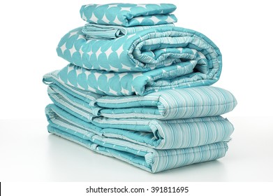 Closeup Of Blue Crib Bedding Stacked Against White Background