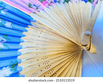 closeup of blue hand fan, concept, Chinese design souvenir, made of bamboo with floral motifs. isolated white background - Powered by Shutterstock