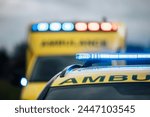 Close-up of blue light flasher on roof of ambulance car of emergency medical service on road. Themes rescue, urgency and health care.	
