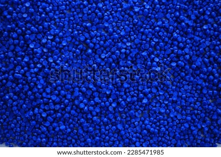 Close-up of blue plastic polymer granules. polymer plastic. compound polymer. PVC resin compounds. Tinted plastic granulate for injection moulding process.