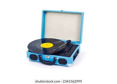 closeup of a blue retro portable turntable playing a disc on a white background
