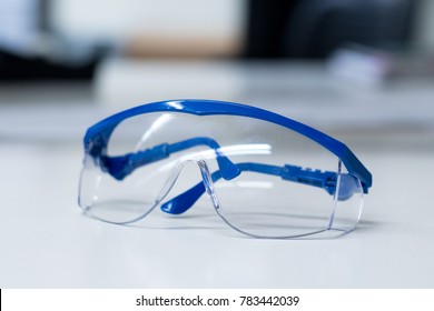 Close-up of blue safety goggles on a desk in a research lab. - Shutterstock ID 783442039