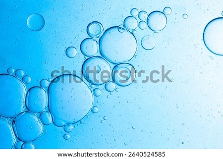 Close-up blue science experiment bubble texture,Bubbles in clear liquid, water or gel texture, oil drop, beauty collagen serum, hyaluronic essence skin care smear, aqua purity, abstract background.
